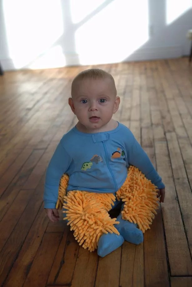 Baby mop romper suit helps crawling infants clean floors as they crawl